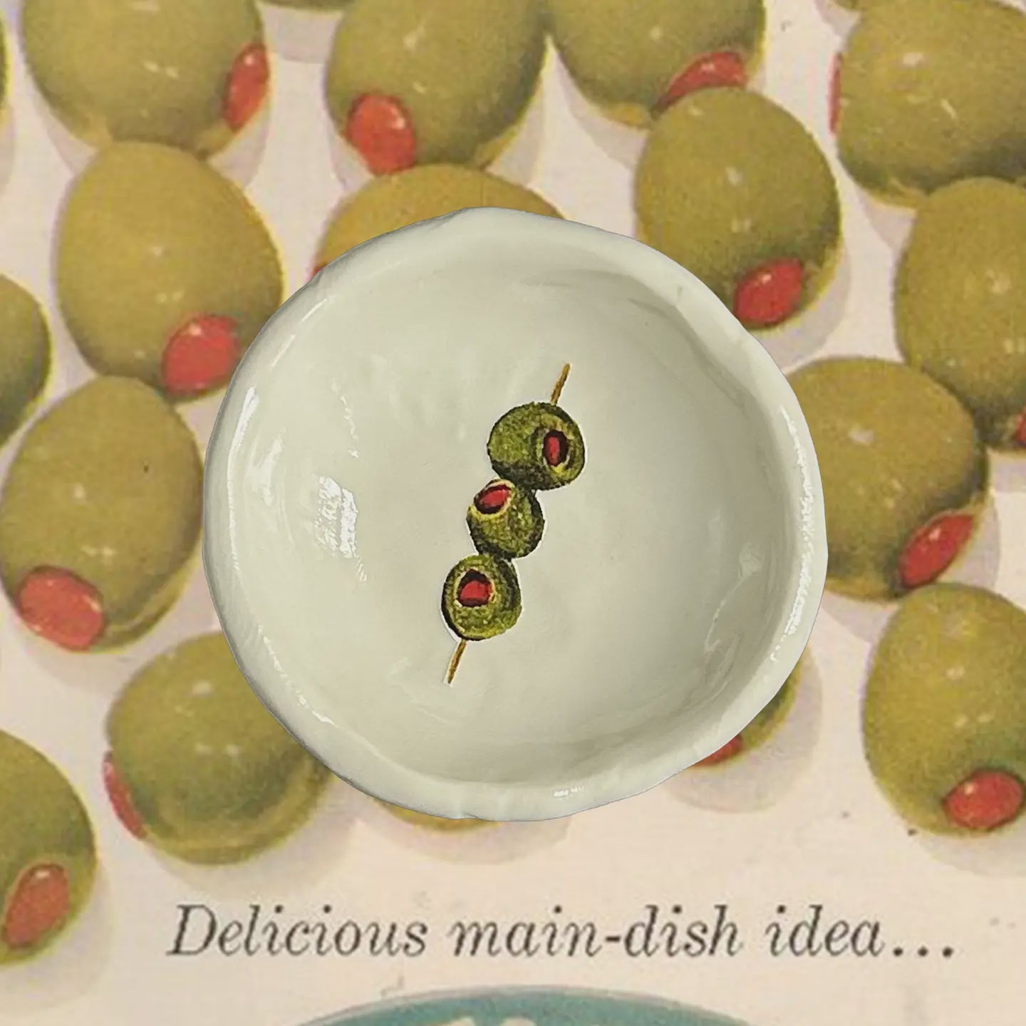 Small bowl with three olives on a background of more olives with text 'Delicious main-dish idea...'