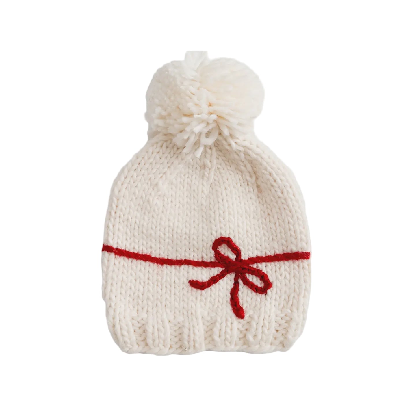 White knitted hat with a red bow and pom-pom on a light gray background