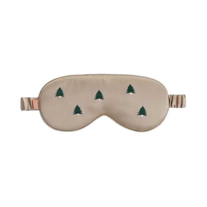 Beige sleep mask with green tree patterns on a white background