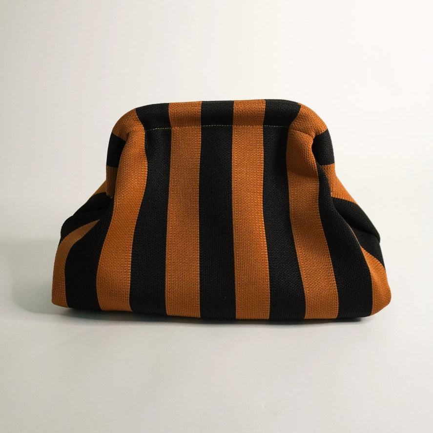 Striped bag with black and orange horizontal stripes on a light gray background