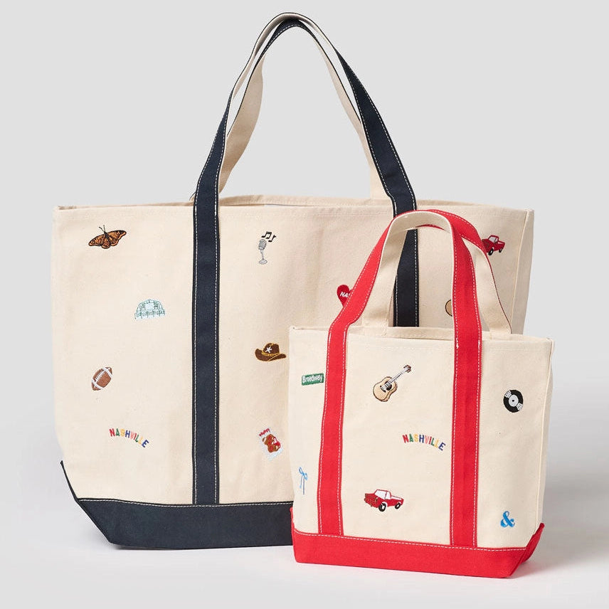 Two tote bags with embroidered designs on a light gray background