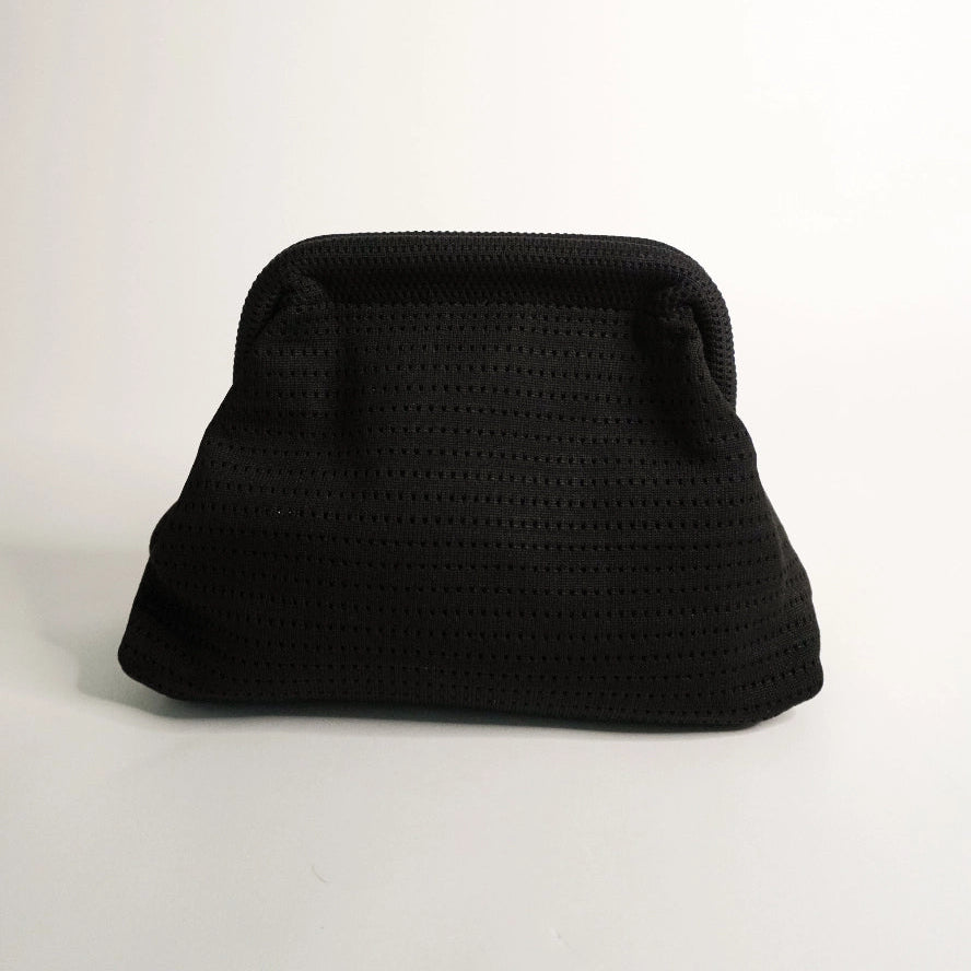Black textured clutch bag on a light gray background