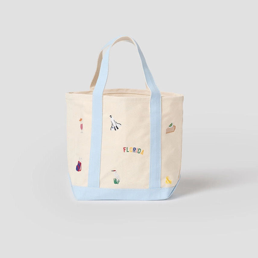 Tote bag with colorful designs and text on a light gray background