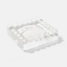 Clear square glass object with embedded round elements on a white background