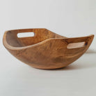 Wooden bowl with handles on a light gray background