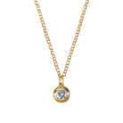 Gold necklace with a diamond pendant on a light gray background