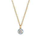 Gold necklace with a round pendant on a light gray background