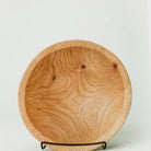 Wooden bowl on a stand with a light gray background